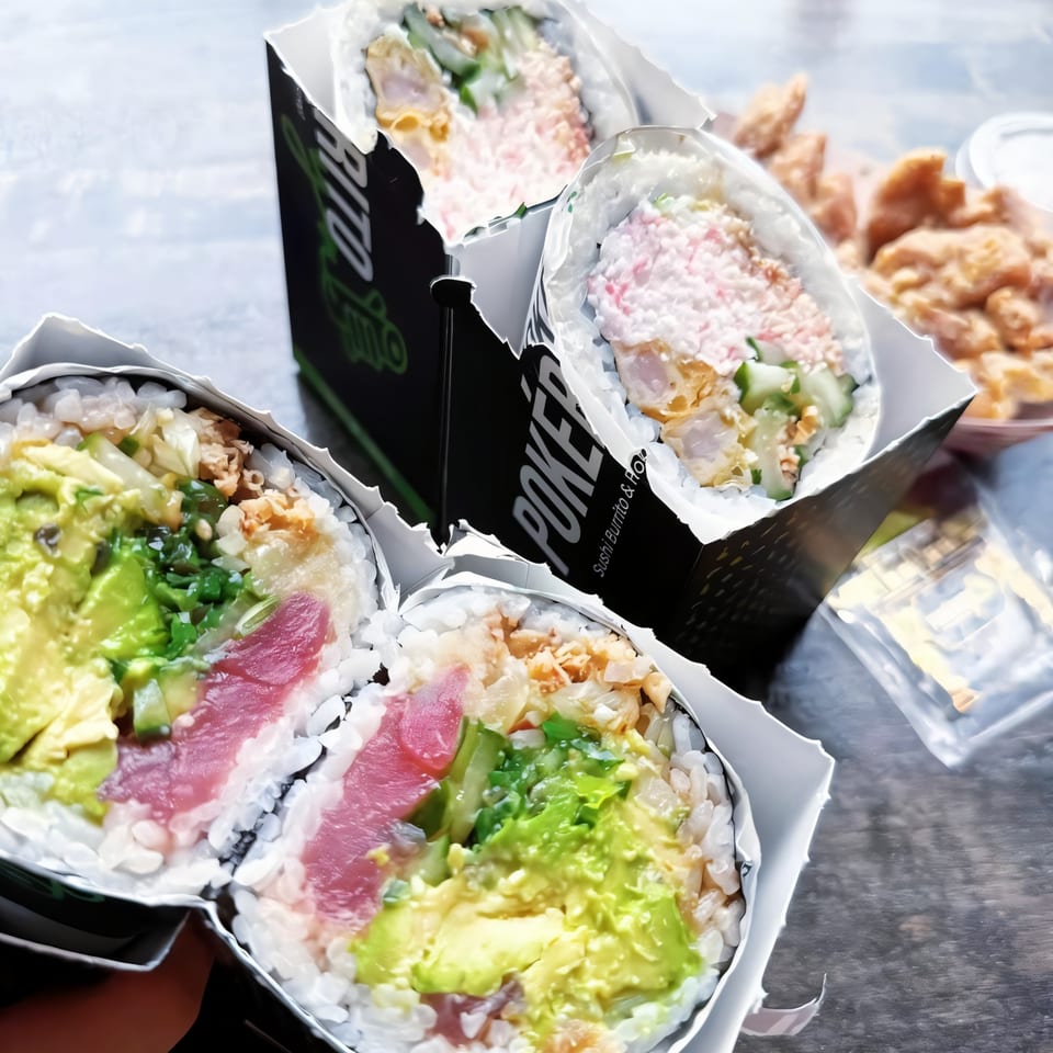 Three Pokérrito Ya sushi burritos, one with tuna and avocado, and a side of fried chicken.